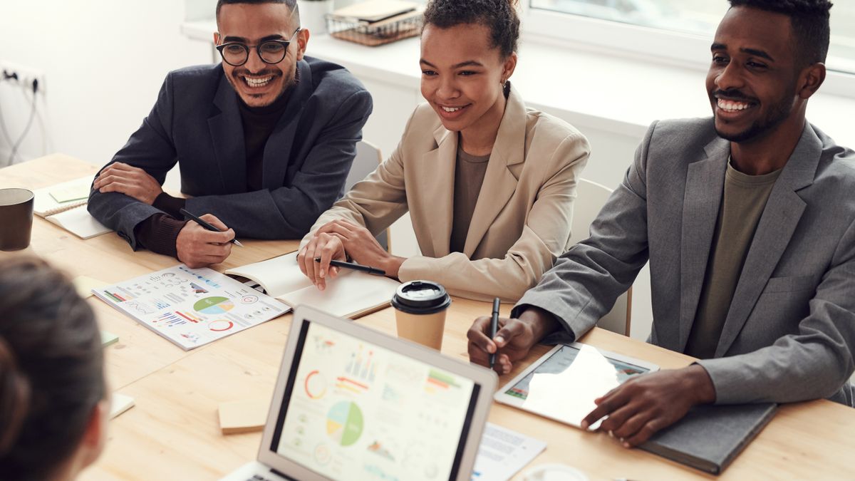 Team reviewing charts and dashboards on a laptop during a business meeting, representing AI reporting
